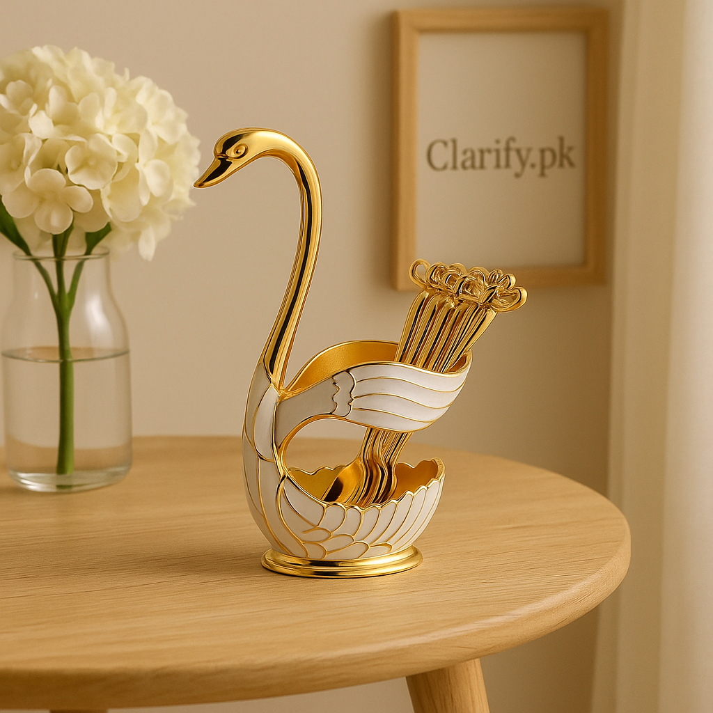 Elegant gold and white swan figurine home decor holding spoons on a wooden table