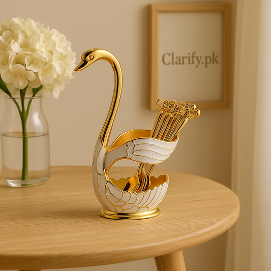 Elegant gold and white swan figurine home decor holding spoons on a wooden table