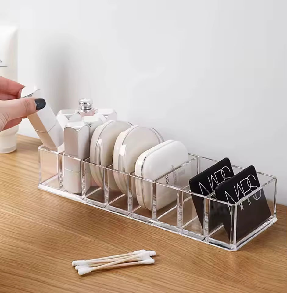 Clear 8 compartment organizer holding makeup products on wooden surface by Clarify.pk