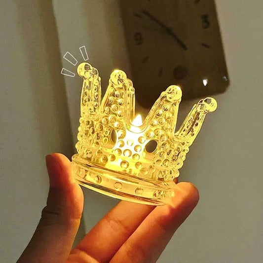 Hand holding a glowing transparent crown night light decor with bubble texture in warm yellow light