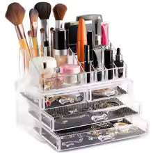 Clear makeup organizer with drawers holding brushes, lipsticks, mascara, and beauty products