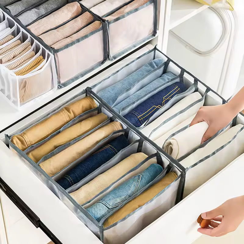 Closet organizer for clothes neatly storing folded pants and tops in a white drawer