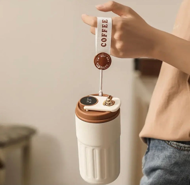 450ml travel coffee mug in white and brown held by a hand with a coffee strap attached