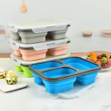 Collapsible silicone lunch box in multiple colors stacked and expanded on kitchen counter with snacks