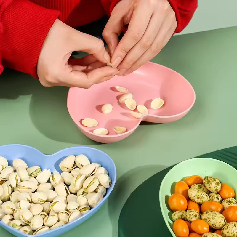 Colorful heart dish pack by Clarify.pk with pink, blue, and green plastic plates holding snacks