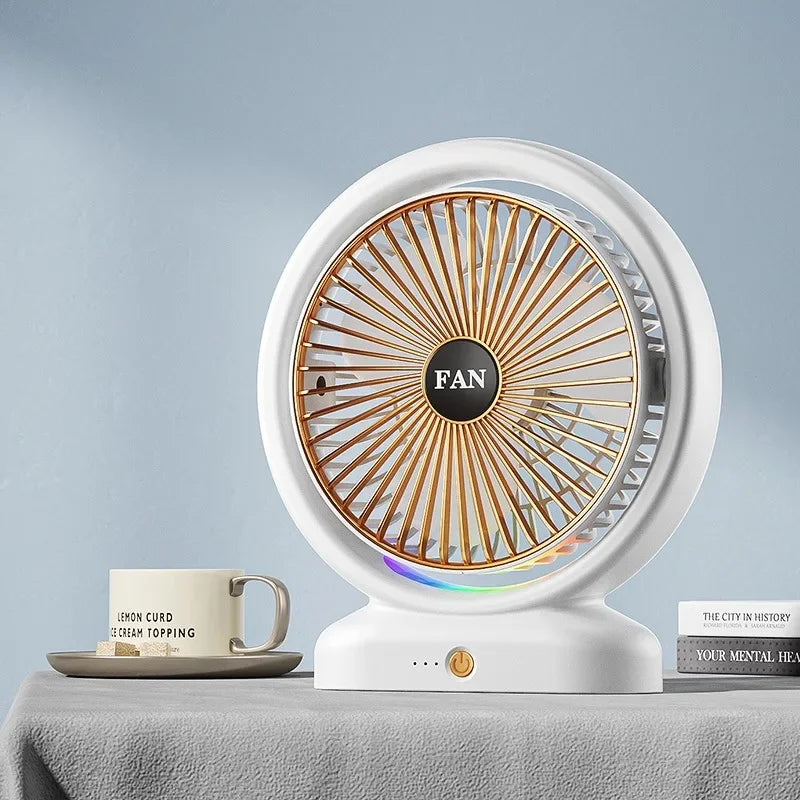 Clarify.pk colorful LED desk fan with white body and golden grille placed on a table next to a coffee cup