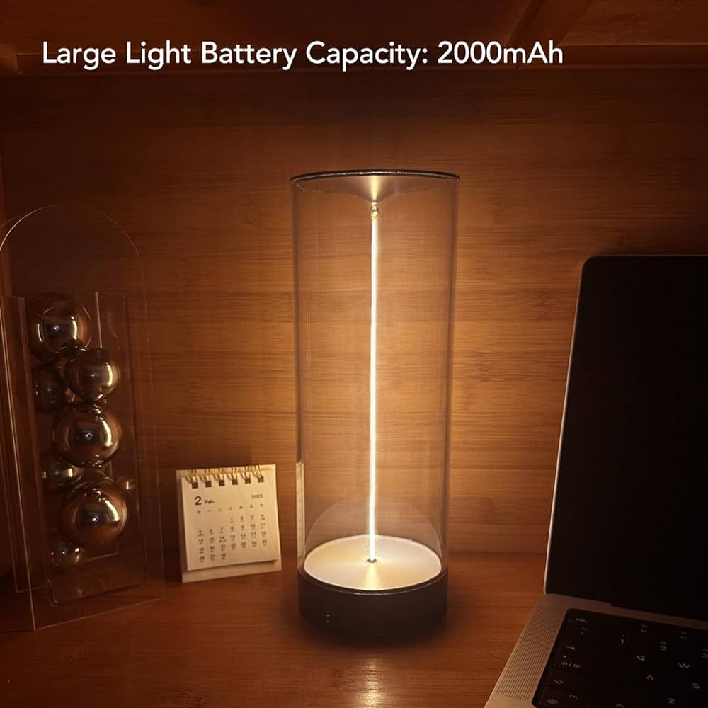 Cordless rechargeable table lamp with large 2000mAh battery glowing on wooden desk next to calendar and laptop