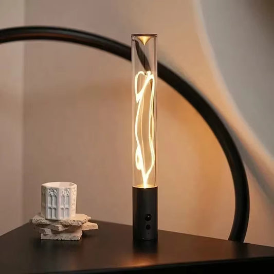 Clarify.pk cordless USB desk lamp with modern glass tube design and warm light glow on black surface