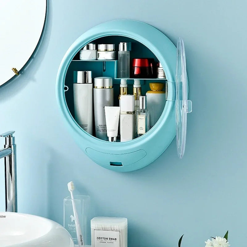 Blue wall-mounted cosmetic storage box with transparent door holding skincare and beauty products