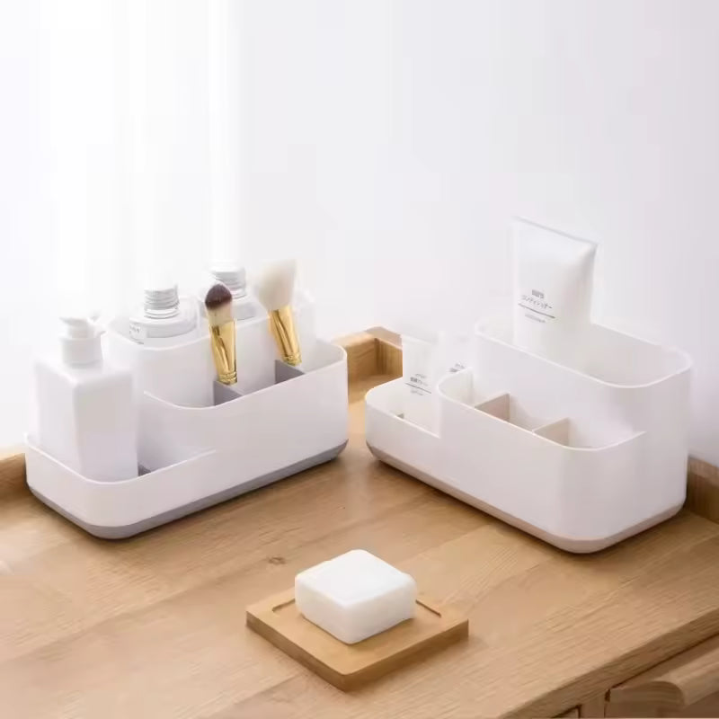 White cosmetic storage box with drawers holding makeup brushes and skincare bottles on wooden surface