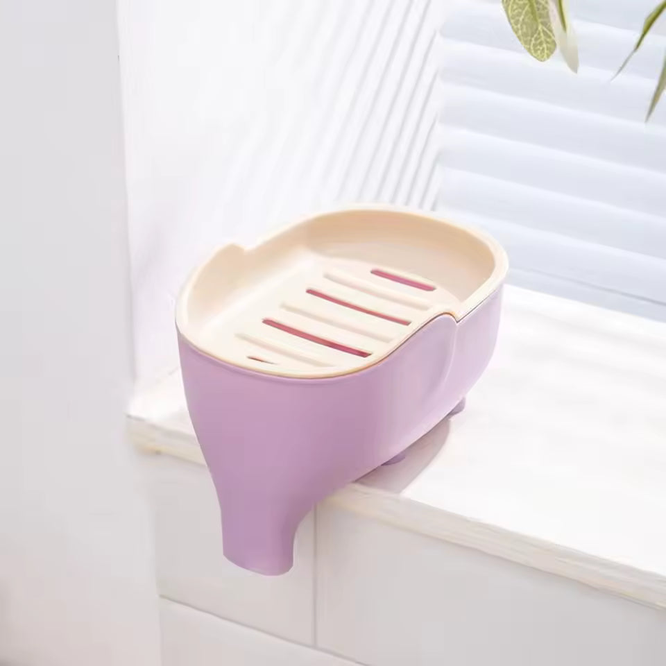 Creative animal soap holder for bathroom in pastel purple and cream colors placed on window ledge