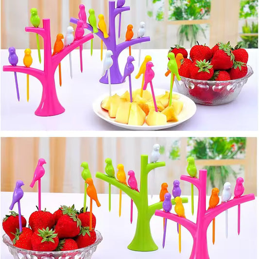 Colorful creative fruit forks set with bird-shaped handles displayed on pink, purple, and green tree stands holding strawberries and pineapple pieces