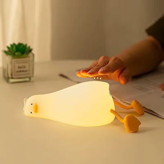 Clarify.pk cute duck night light glowing softly on a desk with hand hovering above it