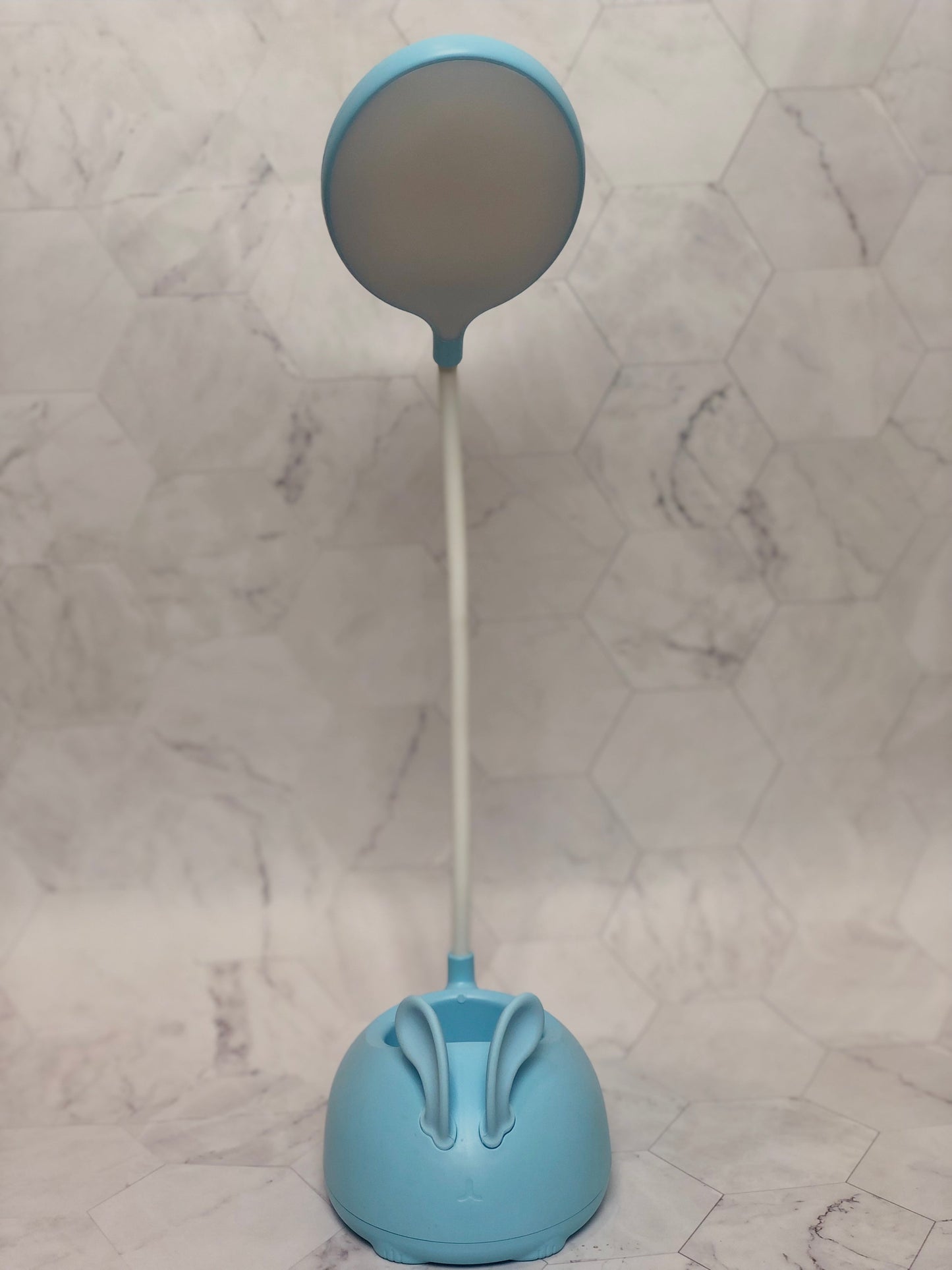 Blue cute rabbit desk lamp with flexible neck and round light head on marble background