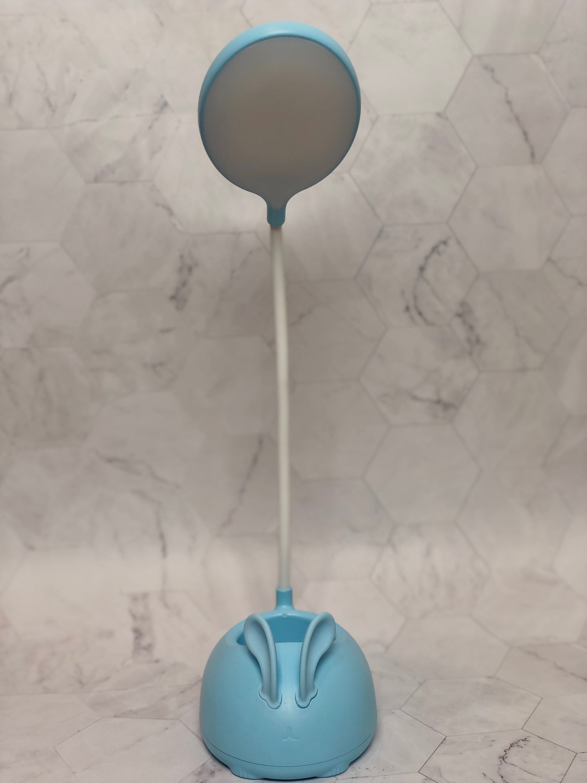 Blue cute rabbit desk lamp with flexible neck and round light head on marble background