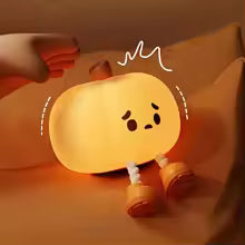 Cute silicone pumpkin night light glowing softly with adorable face and small legs on a cozy surface
