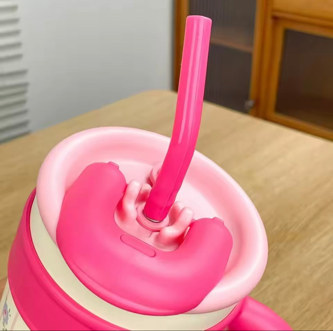 Cute stainless steel tumbler with straw in pink showing close-up of the lid and straw