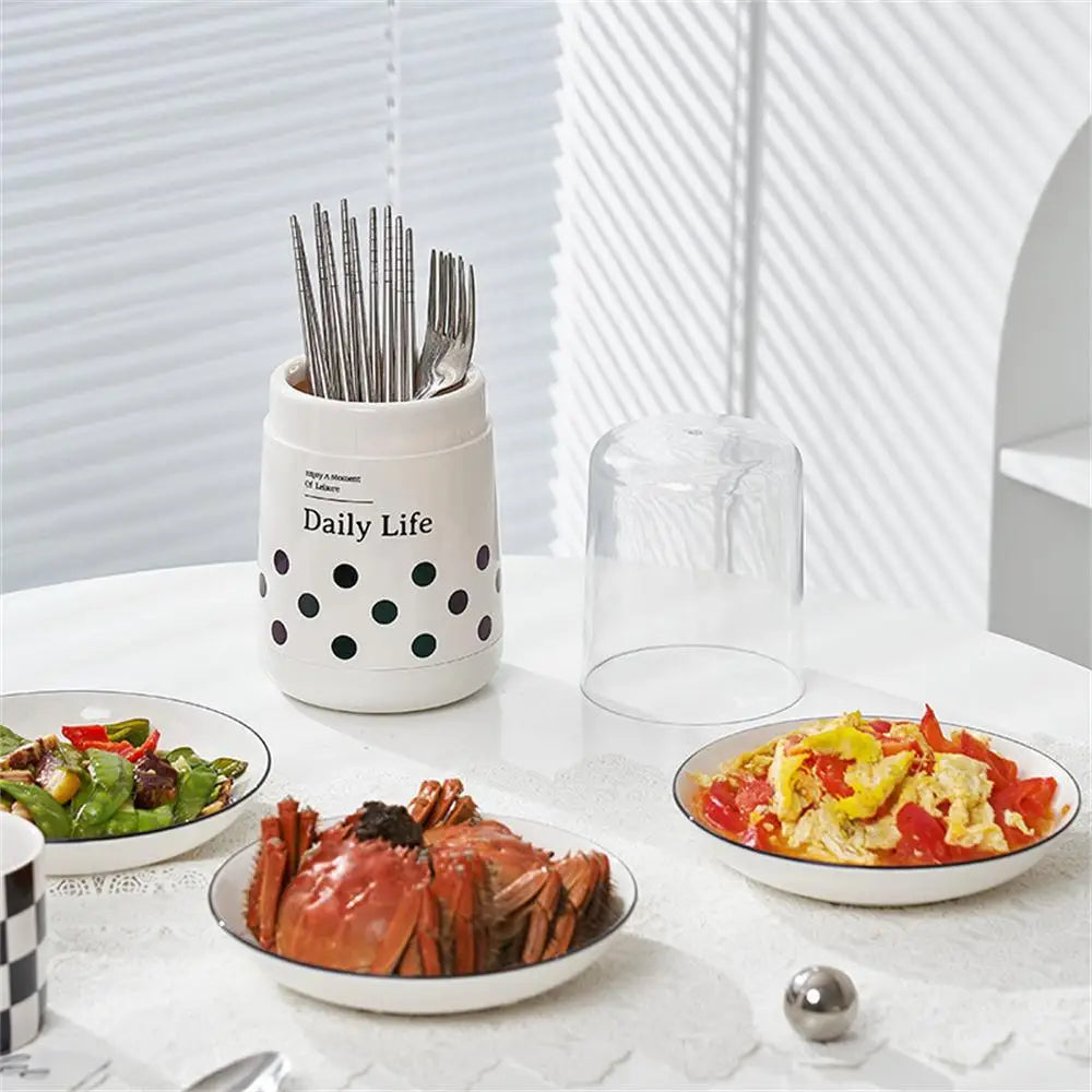 White kitchen utensil holder with lid featuring black polka dots and text Daily Life on a dining table