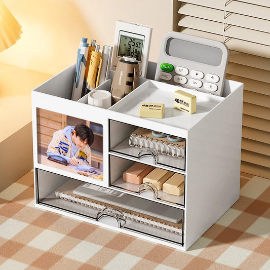 White desktop drawer storage box with multiple compartments holding pens, calculator, sticky notes, and notebooks