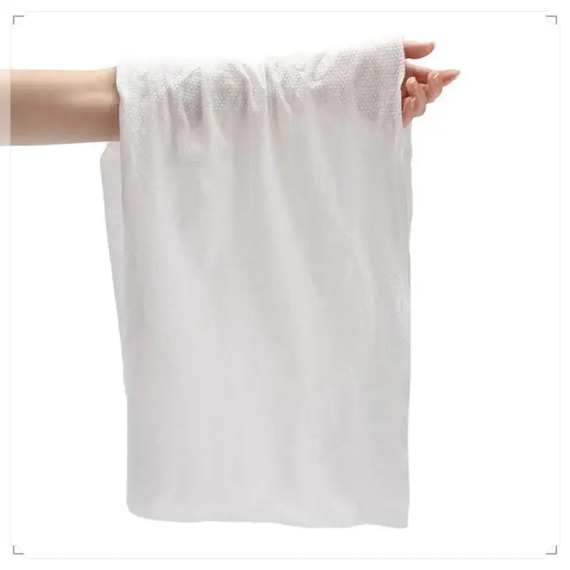 Clarify.pk disposable bath towel held by hand made from soft white fabric ideal for single use