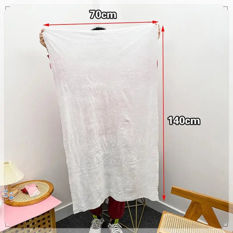 Clarify.pk disposable bath towel in white measuring 70 by 140 cm held by person indoors