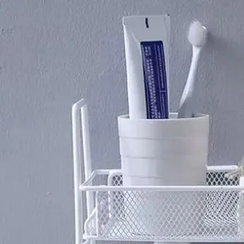 White double layer kitchen storage rack holding a white cup with a toothbrush and toothpaste