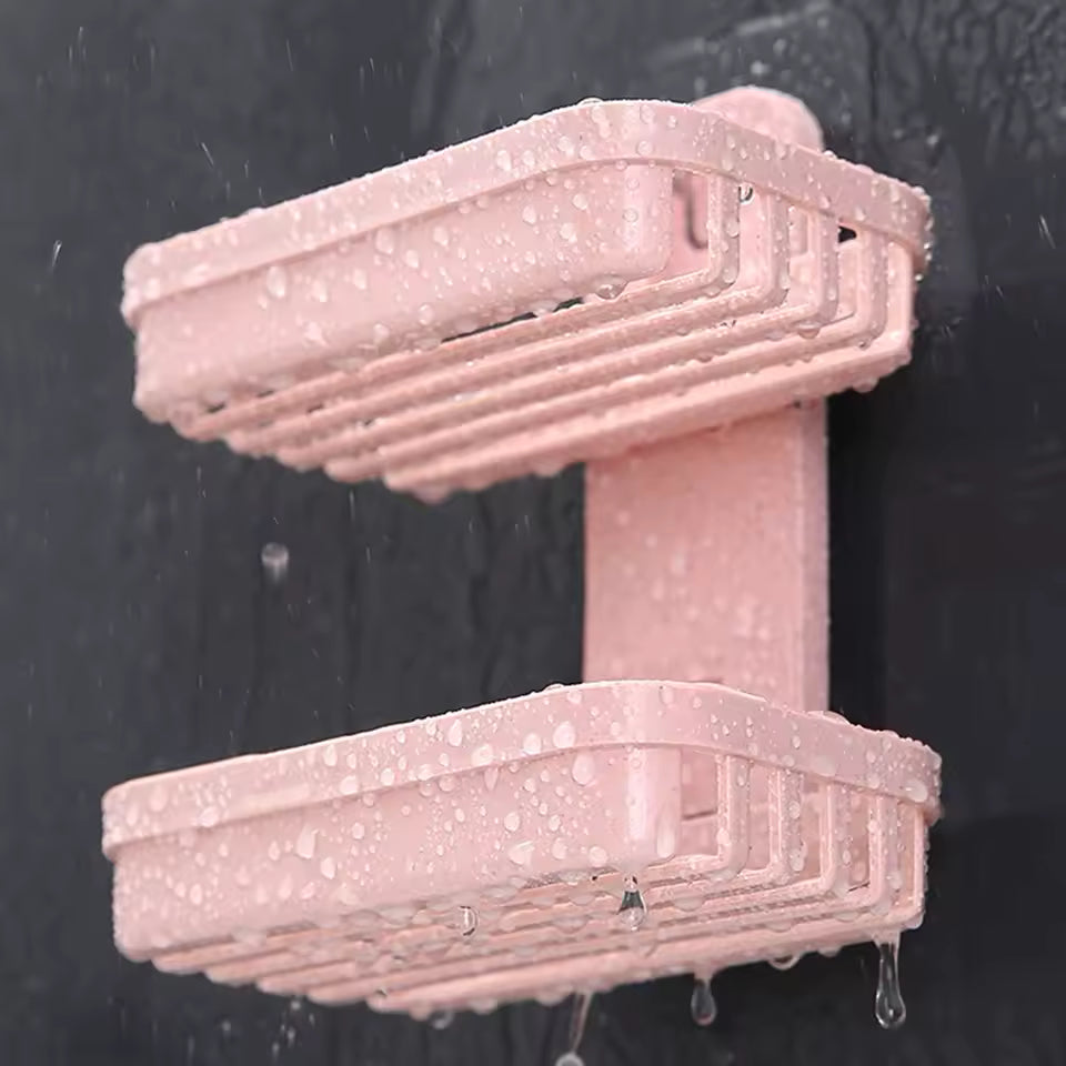 Pink double layer soap dish holder mounted on black wall with water droplets