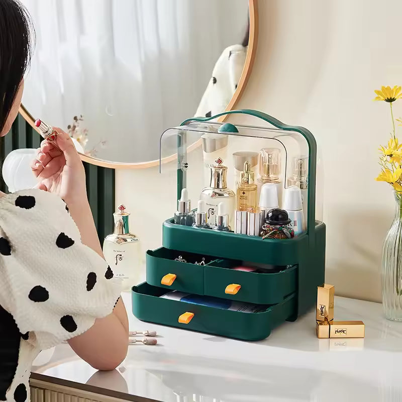 Double sided cosmetic storage box in green with clear cover and drawers holding skincare and makeup items on vanity