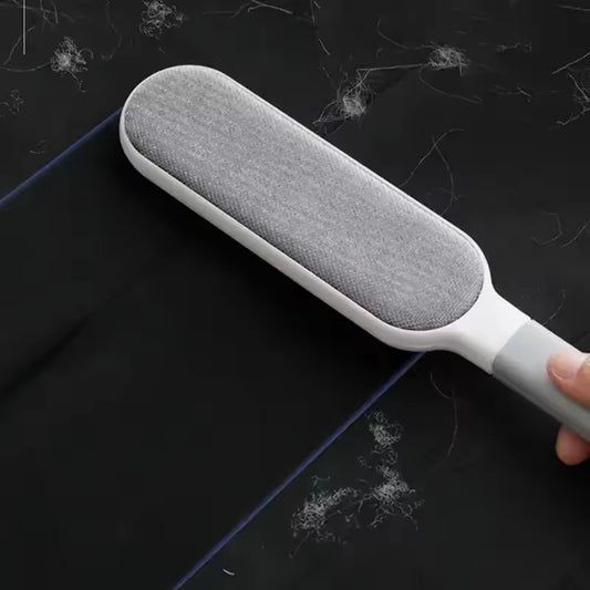 Clarify.pk double sided pet hair remover brush picking up pet hair from black fabric surface