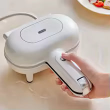 Clarify.pk double sided sandwich press in white with ergonomic handle being held above kitchen counter