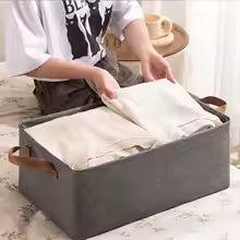 Gray fabric drawer organizer for closet with leather handles storing folded clothes