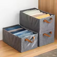 Gray fabric drawer organizer for closet with leather handles holding folded clothes neatly