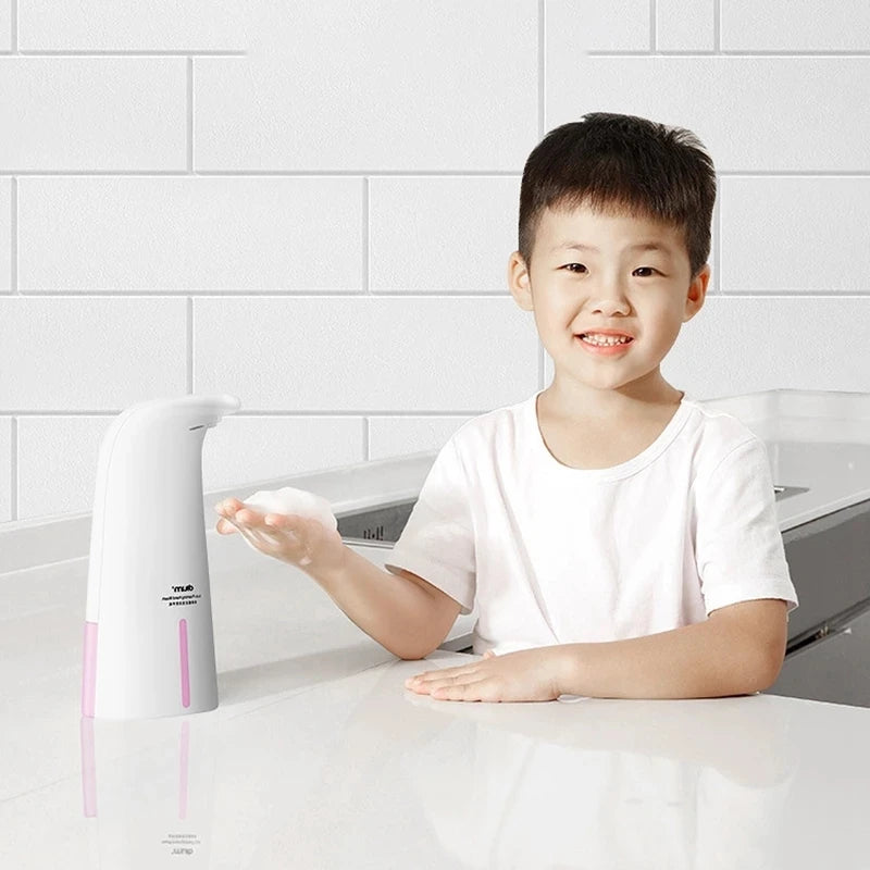 Child using Clarify.pk automatic foam soap dispenser on white kitchen countertop