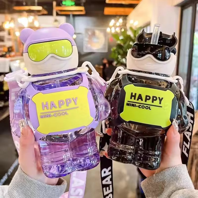 Two colorful 800ml Sports Water Bottle With Straw in bear-shaped design held indoors