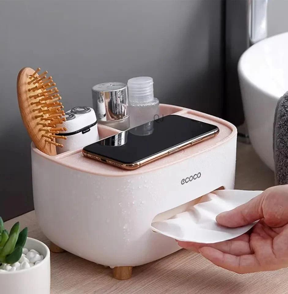 Ecoco tissue box holder in white with compartments holding phone, brush, and bottles on wooden surface
