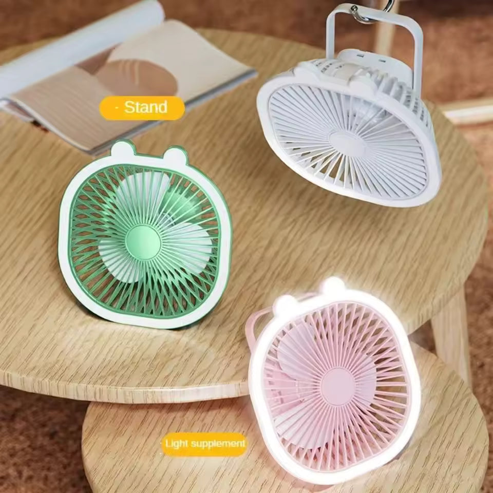 Clarify.pk electric cooling fan with night light in pink, green, and white on wooden table