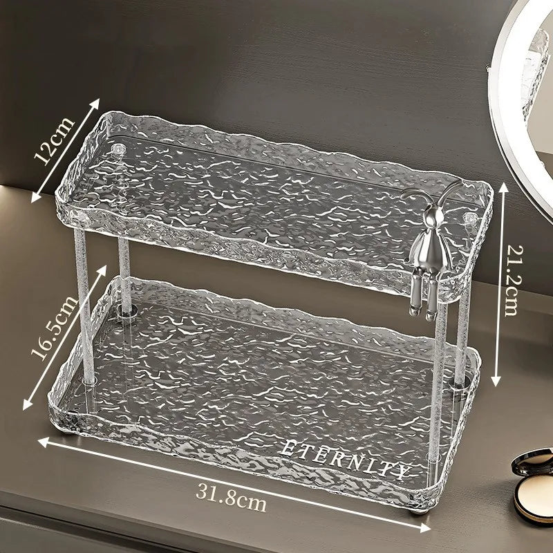 Clear two-tier bathroom organizer shelves with textured design and metal figurine detail by Clarify.pk