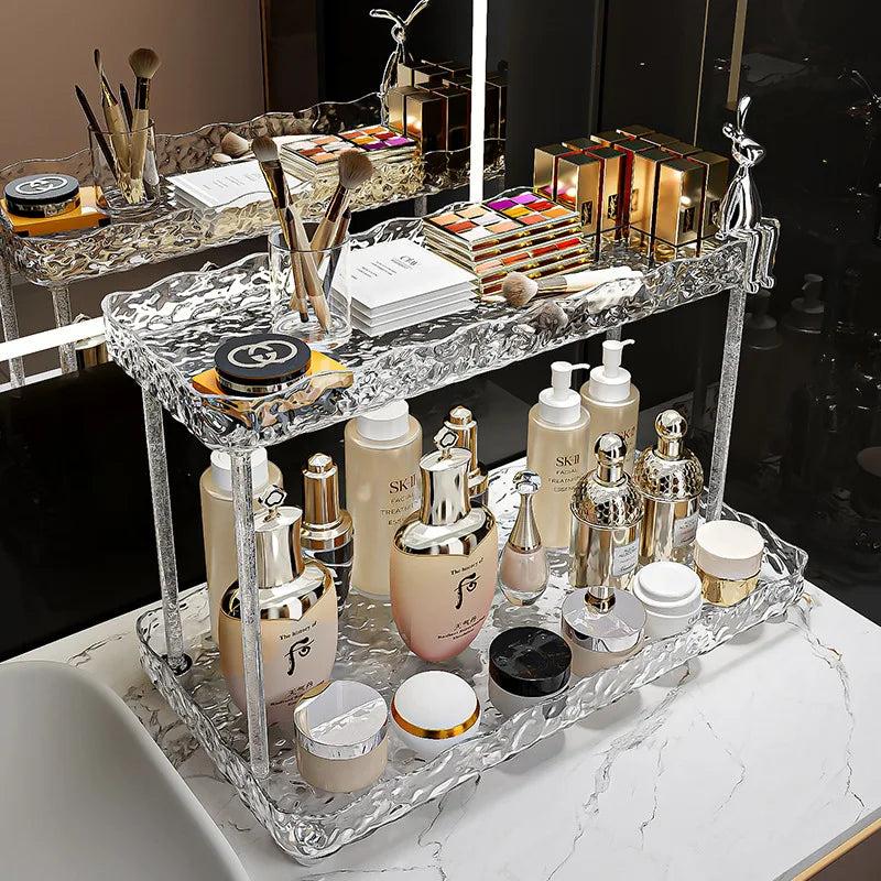 Clarify.pk clear acrylic bathroom organizer shelves holding skincare bottles and makeup items on a marble countertop