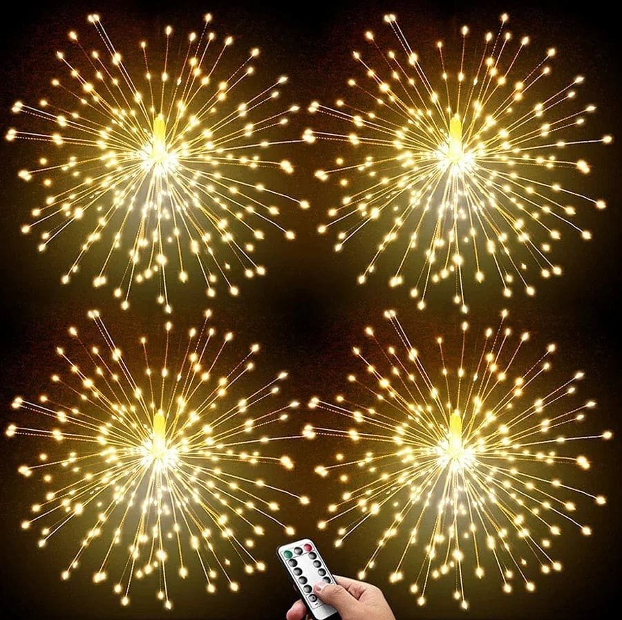 Four golden firework string lights battery operated glowing brightly with remote control in hand