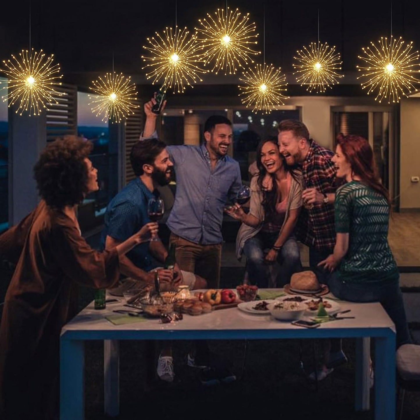 Group of friends enjoying an outdoor dinner under firework string lights battery operated hanging decoration