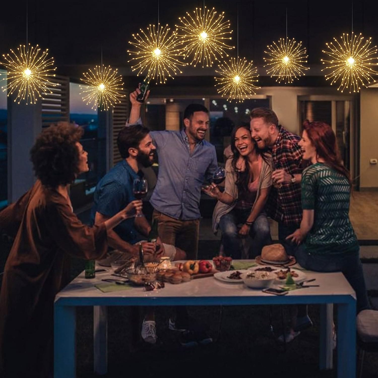 Group of friends enjoying an outdoor dinner under firework string lights battery operated hanging decoration