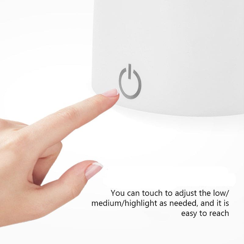 Finger touching the power button on a flexible smart LED desk lamp to adjust brightness levels