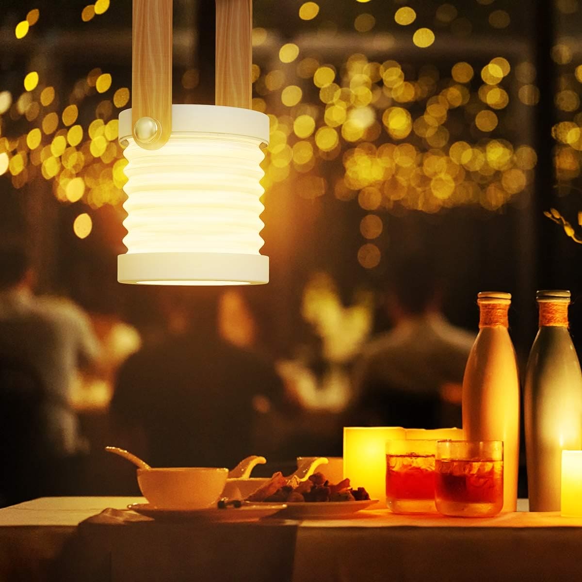 Clarify.pk foldable LED table lamp hanging above a dinner table with drinks and food in warm ambient lighting