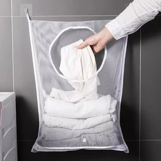 Foldable mesh clothes organizer hanging on bathroom wall with white laundry inside