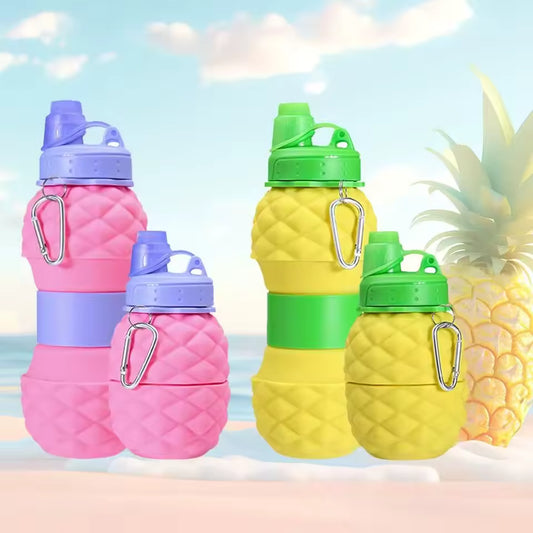 Colorful pink and yellow foldable silicone bottle 700ml with carabiner clips by Clarify.pk on beach background