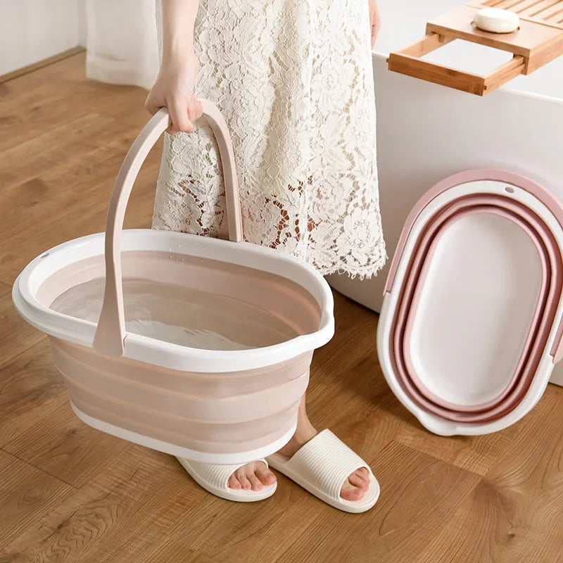 Beige and white folding mop bucket held by a person wearing a white lace dress and slippers on wooden floor