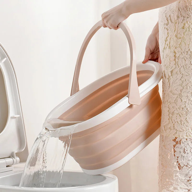 Beige and white folding mop bucket pouring water into a toilet with ergonomic handle