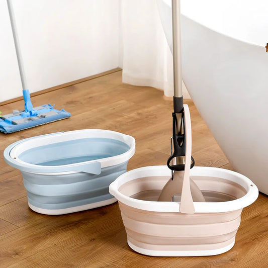 Two collapsible folding mop buckets in blue and beige on wooden floor near a bathtub