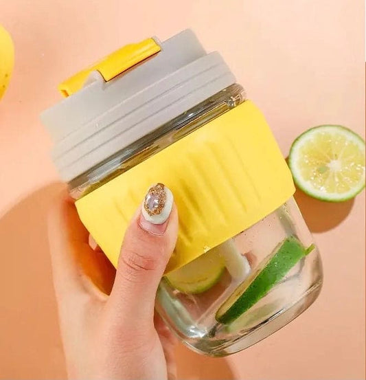 Clarify.pk 350ml cute travel mug with yellow silicone grip and gray lid held in hand with lime slices inside