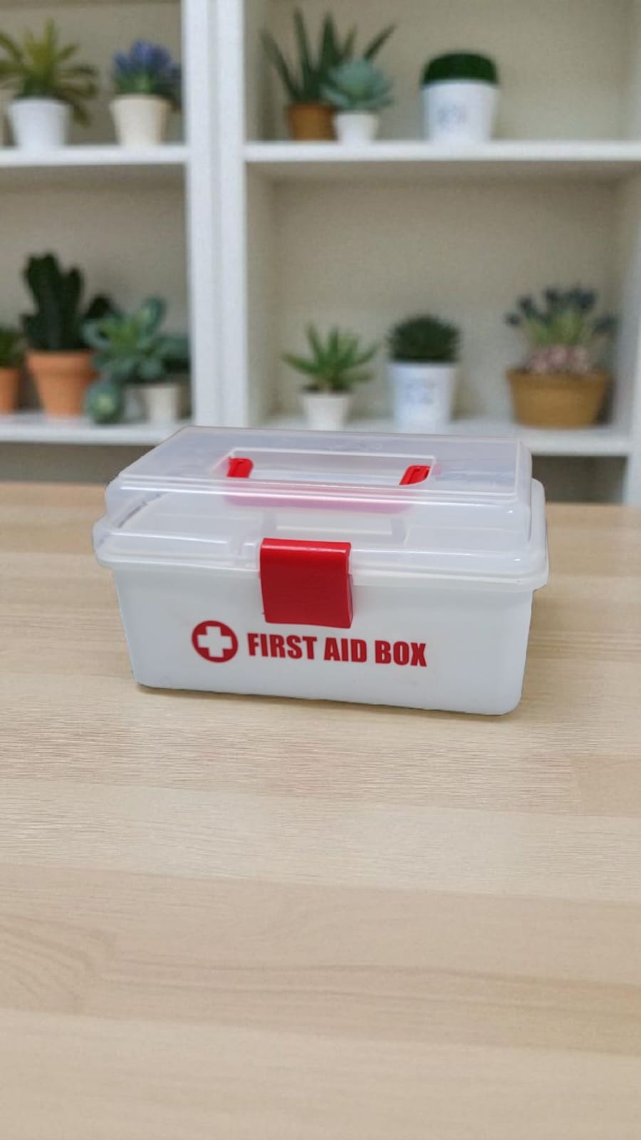 Compact first aid kit box with clear lid and red latch for organized medical supplies